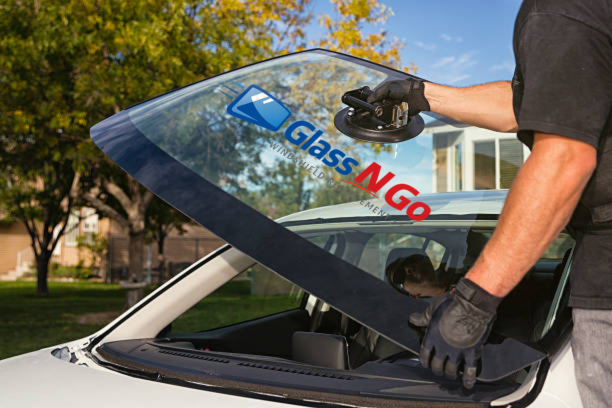 Technician replacing a windshield on a vehicle
